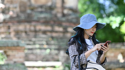 Young travel woman using smartphone in park.
