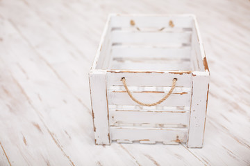 An old empty wooden box on old white background. Scratched vintage white box with peeling paint. Shabby chic or rustic style