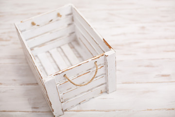An old empty wooden box on old white background. Scratched vintage white box with peeling paint. Shabby chic or rustic style