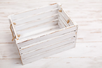 An old empty wooden box on old white background. Scratched vintage white box with peeling paint....