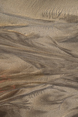 Close-up pictures of the natural origin created by the ocean on wet sand in the low tide zone