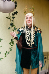 A man dressed in an elf costume. Elf with white hairs in the interior