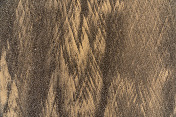 Interesting textured patterns formed in the low tide zone of fine sand in two colors: ordinary golden and black lava