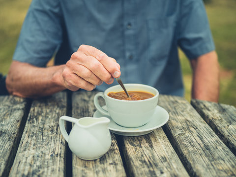 Senior man drinking coffee with milk outdoors