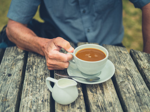 Senior man drinking coffee with milk outdoors