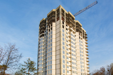 Fototapeta premium Construction of new house or building. General view. Unfinished cement building in the summer. The introduction of urbanization into nature. Capital construction in Ukraine