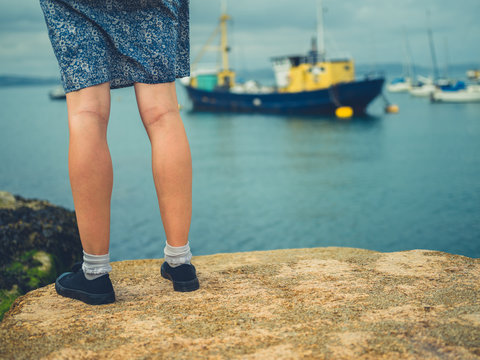 Legs of young woman standing in harbor