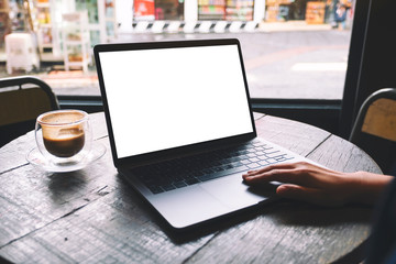 Fototapeta premium Mockup image of a woman using and touching on laptop touchpad with blank white desktop screen on wooden table