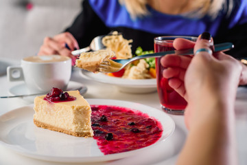 Cheesecake with berry jam on a white plate in the restaurant. close up. blure. space.