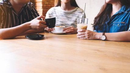 Closeup image of friends enjoyed talking and drinking coffee together in cafe