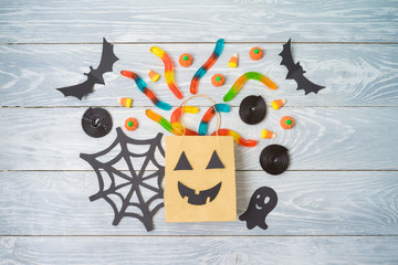 Halloween holiday party background with gift paper bags and candy .Top view from above. Flat lay