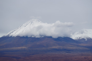 Fototapeta na wymiar View of the Licancabur volcano covered by clouds, Atacama Desert, Chile