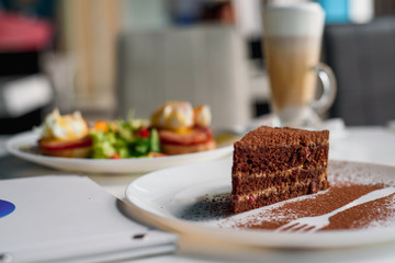 chocolate dessert on a white plate on a light table in a restaurant. Close-up. Traditional chocolate cake