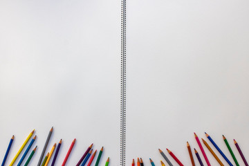 the color pencils below on a drawing block with spiral in center...