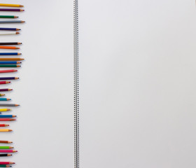 the color pencils on a drawing block with spiral...