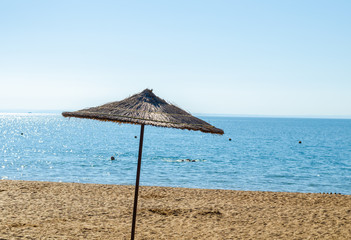 Canopy of straw in the form of an umbrella in the summer on the beach.