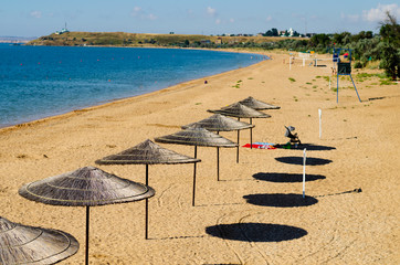 Straw umbrella on the beach.Shelter from the sun near the sea.