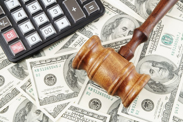 Judge gavel, calculator and dollar banknotes 