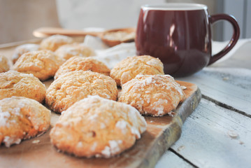 Cup with hot coffee and cookies on a white wooden table. Homemade baking.