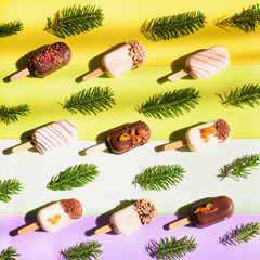 Ice cream and christmas decor on bright striped background.