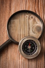 Metallic compass on wooden background