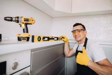 Maintenance man installing kitchen furniture