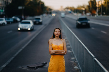 A young woman stands on a background of cityscape.