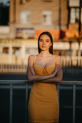A young woman stands on a background of cityscape.