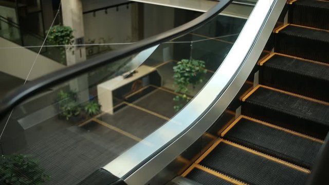 Escalator in motion in a business center, front desk visible on the ground floor