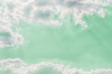 Delicate light rays through clouds on a pastel green color sky background