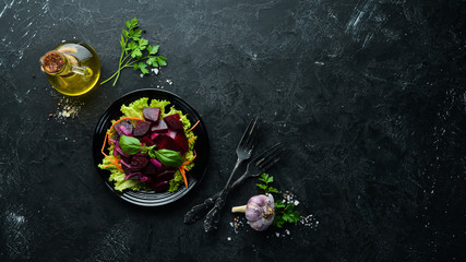 Beet salad with onions in a black plate on a black background. Top view. Free space for your text.