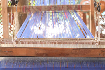 Weaving loom with thread to weave into fabric.