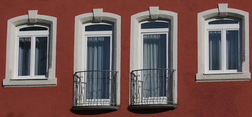 Hausfront mit verschiedenen Fenstern.