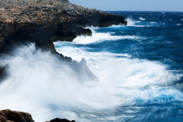 Waves breaking on rocky shoreline in Greece. Long Exposure of the Mediterranean Sea