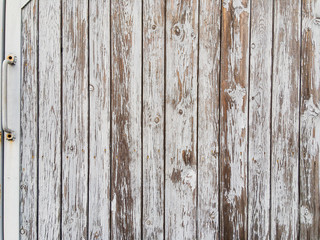 Wooden boards on the gates with an iron handle, covered with old, peeling paint. Background image.