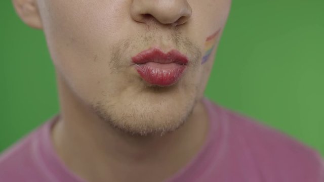 Bearded man with painted lips kiss on the camera. LGBT community. Transsexual