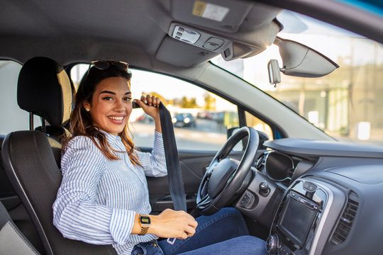 Safety first. Beautiful caucasian lady fastening car seat belt. Pretty young woman driving her new car. Pretty young woman driving her new car. Female fastening safety belt in car