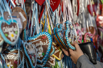 hands of a women on a typical gingerbread hearts at the oktoberfest in munich 2019 with the word Oktoberfest 2019 on it