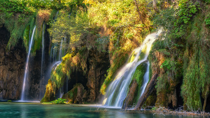 Breathtaking waterfalls panorama in Plitvice Lakes National Park, Croatia, Europe. Majestic view with turquoise water and sunset sunny beams, travel destinations background