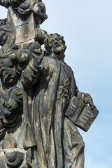 Fototapeta na wymiar A statue of Saint Cajetan, holding a book at the Charles bridge, Prague. Czech repulic.