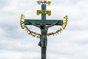  17th Century Crucifixion statue with Hebrew lettering in Charles Bridge Prague, Czech Republic. Prague eldership forced oppressed Jewish people to decorate the statue with gold