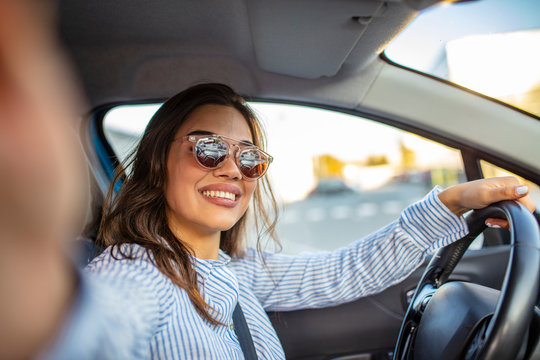 Beautiful young woman on passenger seat in car, taking selfie. Carfie (selfie in the car). Beautiful young woman in car. Beautiful woman making self portrait at car