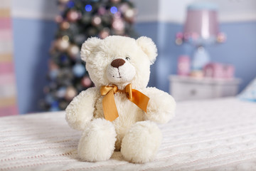 White toy bear on a bed. New year decoration in the bedroom in tender pink and blue colors