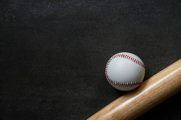 baseball and baseball bat on black table background, close up