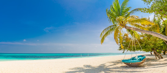 Tropical beach panorama as summer landscape with beach swing or hammock and white sand and calm sea...