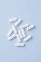 Arginine capsules. Bright paper background. Top view. Copy space. 