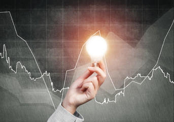 Businesswoman holding in hand glowing light bulb