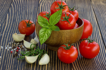 cherry tomatoes,garlic and basil on wooden board outdoors