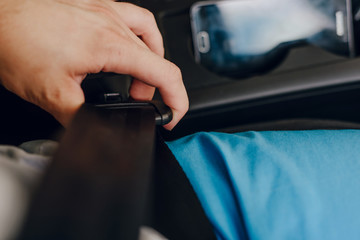 Fastening the seat belts in the car. The man fastens a seat belt in the car. The concept of safety during travel, caring for the safety of the driver and passengers.