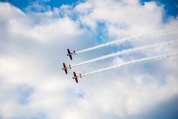 Aerobatics, air show. Aircraft team performing in the sky with old airplanes and drawing lines,...